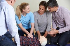 Woman Demonstrating CPR On Training Dummy In First Aid Class stock images Woman Demonstrating CPR On Training Dummy In First Aid Class stock images