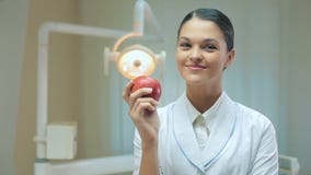 Woman dentist with apple