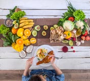 The woman at the dinner table with organic food , the view from the top royalty free stock photos The woman at the dinner table with organic food , the view from the top royalty free stock photos