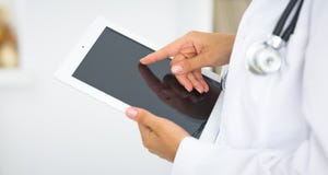 Woman doctor using tablet computer while standing straight in hospital Royalty Free Stock Photo Woman doctor using tablet computer while standing straight in hospital Royalty Free Stock Photo