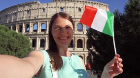 Woman doing selfie near Colosseum in Rome, Italy. Teenage girl waving Italian flag in slow motion stock video footage Woman doing selfie near Colosseum in Rome, Italy. Teenage girl waving Italian flag in slow motion stock video footage