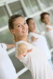 Woman doing stretching excercises during yoga class in group royalty free stock photography Woman doing stretching excercises during yoga class in group royalty free stock photography