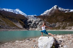 Woman is doing yoga excercises near big lake on the Manaslu circ Royalty Free Stock Photography Woman is doing yoga excercises near big lake on the Manaslu circ Royalty Free Stock Photography