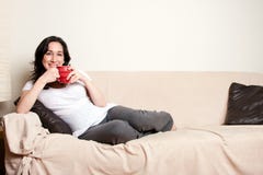 Woman with drink on couch Stock Images Woman with drink on couch Stock Images