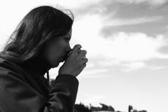 Woman is drinking tea on the waterfront. Young brunette on a journey. Bw. stock photos Woman is drinking tea on the waterfront. Young brunette on a journey. Bw. stock photos