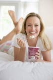 Woman Eating Ice Cream in Bed