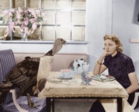 Woman eating meal at table with live turkey