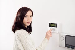 Woman entering code on keypad of home security alarm Stock Photos Woman entering code on keypad of home security alarm Stock Photos