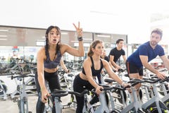 Woman Gesturing Victory While Exercising On Spinning Bike In Gym Royalty Free Stock Images Woman Gesturing Victory While Exercising On Spinning Bike In Gym Royalty Free Stock Images