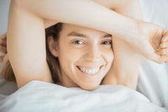 Woman smiling in camera in bed royalty free stock images Woman smiling in camera in bed royalty free stock images