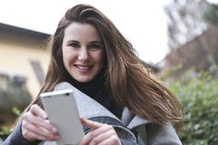 Woman in Gray Coat Holding White Smartphone Stock Images Woman in Gray Coat Holding White Smartphone Stock Images