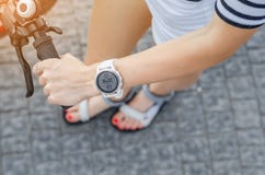 Woman hand on bicycle handlebar, white smart watch on wrist