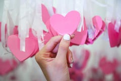 Woman Hand pick pink heart shape Lucky Draw attached to white ribbon on wishing tree in charity event. Games, that prizes are royalty free stock images Woman Hand pick pink heart shape Lucky Draw attached to white ribbon on wishing tree in charity event. Games, that prizes are royalty free stock images
