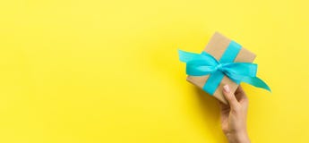 Woman Hands Give Wrapped Valentine Or Other Holiday Handmade Present In Paper With Blue Ribbon. Present Box, Decoration Of Gift On Stock Image Woman Hands Give Wrapped Valentine Or Other Holiday Handmade Present In Paper With Blue Ribbon. Present Box, Decoration Of Gift On Stock Image