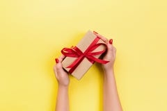 Woman Hands Give Wrapped Valentine Or Other Holiday Handmade Present In Paper With Red Ribbon. Present Box, Decoration Of Gift On Royalty Free Stock Photography