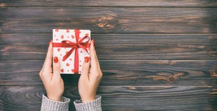 Woman Hands Give Wrapped Valentine Or Other Holiday Handmade Present In Paper With Red Ribbon. Present Box, Red Heart Of Gift On Royalty Free Stock Photos Woman Hands Give Wrapped Valentine Or Other Holiday Handmade Present In Paper With Red Ribbon. Present Box, Red Heart Of Gift On Royalty Free Stock Photos