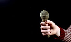 Woman Hands Holding Dirty And Dusty Microphone On A Dark Background Royalty Free Stock Photo