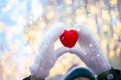 Woman Hands In White Knitted Mittens With A Red Heart On A Snow Background. Stock Image Woman Hands In White Knitted Mittens With A Red Heart On A Snow Background. Stock Image