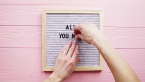 Woman Hands Putting Phrase All You Need Is Love On Gray Letter Board With Black Plastic Letter, Pink Wooden Background Royalty Free Stock Photos