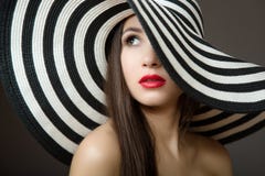 Woman in a hat and with red lips. Portrait of a young beautiful brunette. Dark background stock images Woman in a hat and with red lips. Portrait of a young beautiful brunette. Dark background stock images