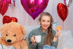 Woman having breakfast with waffles and tea in bed on valentine`s day