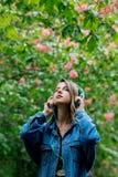 Woman with a headphones at blossom trees on background royalty free stock photos Woman with a headphones at blossom trees on background royalty free stock photos