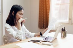Woman holding agreement documents and using laptop on table in office room, to plan advance budget. royalty free stock photo Woman holding agreement documents and using laptop on table in office room, to plan advance budget. royalty free stock photo