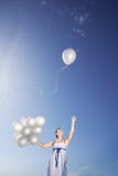 Woman Holding Balloons With One Flying Away