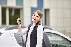 Woman holding keys to new car auto and smiling at camera royalty free stock photo Woman holding keys to new car auto and smiling at camera royalty free stock photo