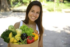 Woman holding shopping paper bag with organic or bio vegetables and fruits.