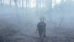 Woman in image of witch walks across dark and foggy forest
