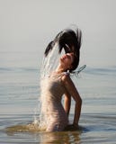 Woman In The Sea Splashing Water Stock Images