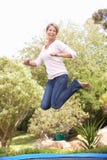 Woman Jumping On Trampoline In Garden stock images Woman Jumping On Trampoline In Garden stock images