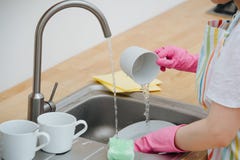 Woman in a kitchen is washing cups and dishes. Close up. stock images Woman in a kitchen is washing cups and dishes. Close up. stock images
