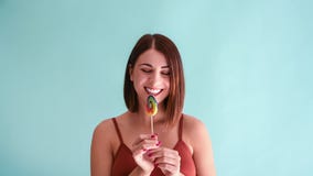Woman licks and kisses lollipop