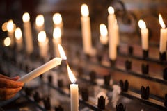 Woman lighting prayer candle