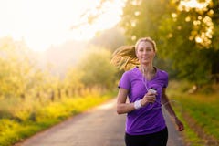 Woman listening to music while jogging royalty free stock image Woman listening to music while jogging royalty free stock image