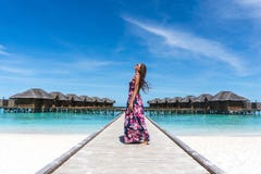 Woman looking in the air on bridge on beach in Maldives