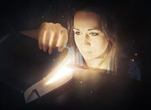 Woman looking into glowing Bible.