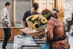 Woman looking at jewelry, holding a bunch of sunflowers purchased at the Columbia Road Flower Market, London, UK stock image Woman looking at jewelry, holding a bunch of sunflowers purchased at the Columbia Road Flower Market, London, UK stock image