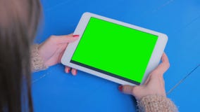 Woman looking at tablet computer with green screen