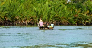 Woman moving by rowing boat, the most common transportation mean of rural people in Mekong delta Royalty Free Stock Image Woman moving by rowing boat, the most common transportation mean of rural people in Mekong delta Royalty Free Stock Image