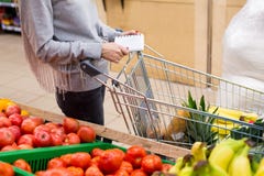 Woman with notebook in grocery store, closeup. Shopping list on paper. Stock Photos Woman with notebook in grocery store, closeup. Shopping list on paper. Stock Photos