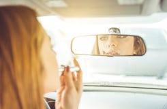 Woman putting lipstick in the car. royalty free stock image Woman putting lipstick in the car. royalty free stock image