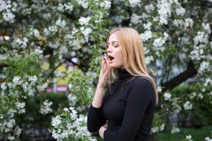 Woman reacts with asthma on hay fever while being in park stock photography Woman reacts with asthma on hay fever while being in park stock photography