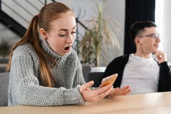 Woman reading her man`s cheating messages on his phone stock image Woman reading her man`s cheating messages on his phone stock image