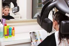 Woman reading magazine in hair beauty salon. By hairdresser. Royalty Free Stock Photos Woman reading magazine in hair beauty salon. By hairdresser. Royalty Free Stock Photos