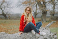 Woman in Red Sweater Sitting on Cutted Tree Royalty Free Stock Images Woman in Red Sweater Sitting on Cutted Tree Royalty Free Stock Images