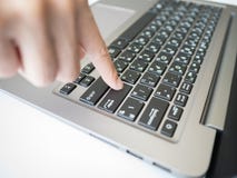 Woman`s finger pushing enter button on notebook keyboard stock photography Woman`s finger pushing enter button on notebook keyboard stock photography