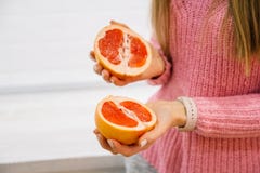 Woman`s hands cutting fresh grapefruit on kitchen. Girl cutting orange with knife. Healthy lifestyle concept. stock photo Woman`s hands cutting fresh grapefruit on kitchen. Girl cutting orange with knife. Healthy lifestyle concept. stock photo